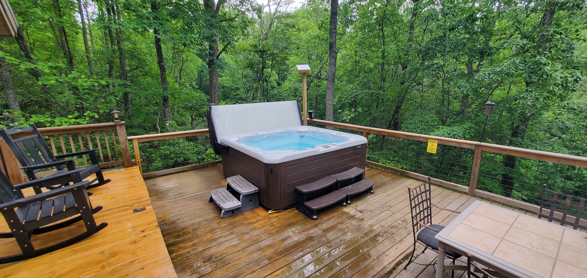 Hot tub on deck surrounded by forest